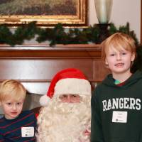 Two brothers sitting with Santa together.